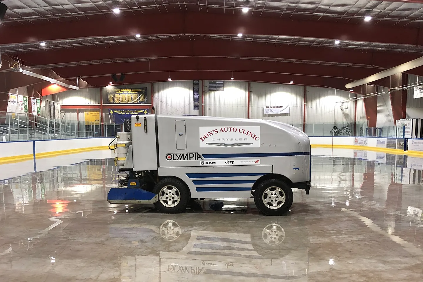 Una pulidora de hielo sobre la pista recién renovada, con las vallas, el cristal y el techo de acero iluminado de la arena detrás. — Wexford Civic Center