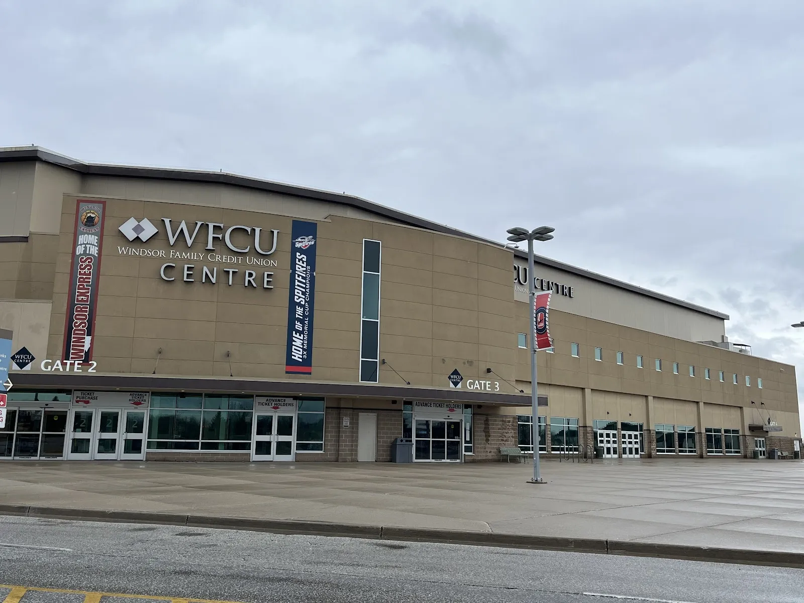 La fachada color canela del WFCU Centre con su letrero y la entrada Gate 2, al otro lado del estacionamiento. — WFCU Centre