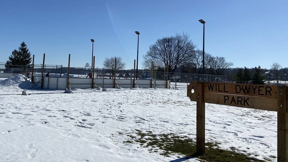 The Will Dwyer Park sign in Barrie with the snow-covered community rink behind it. — Will Dwyer Park Community Ice Rink (Barrie)