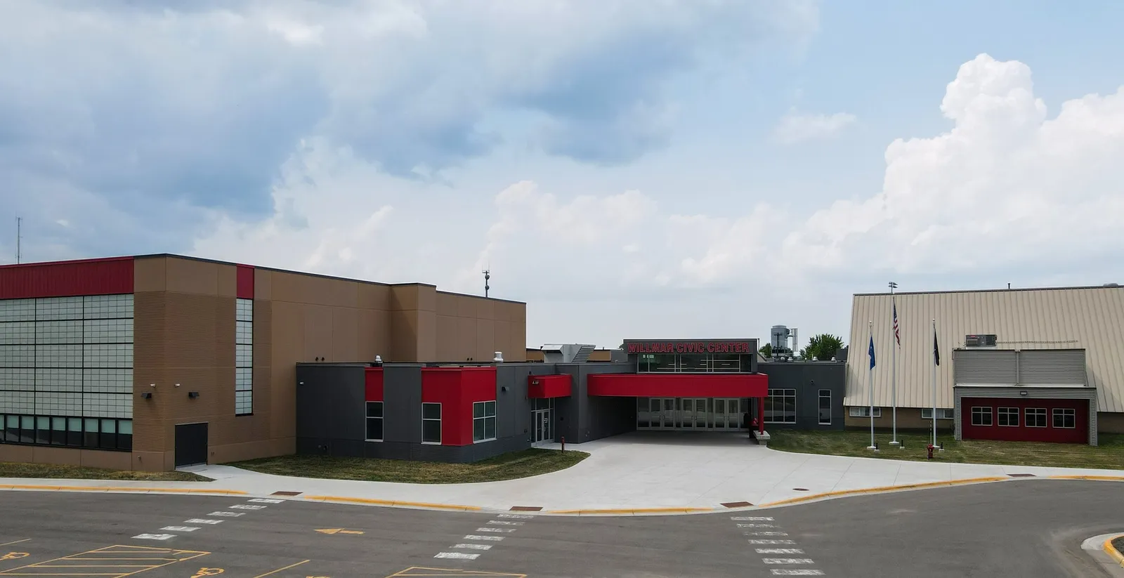 The Willmar Civic Center seen from the car park: a modern brick and glass building with red trim and a flat entrance front. — Willmar Civic Center