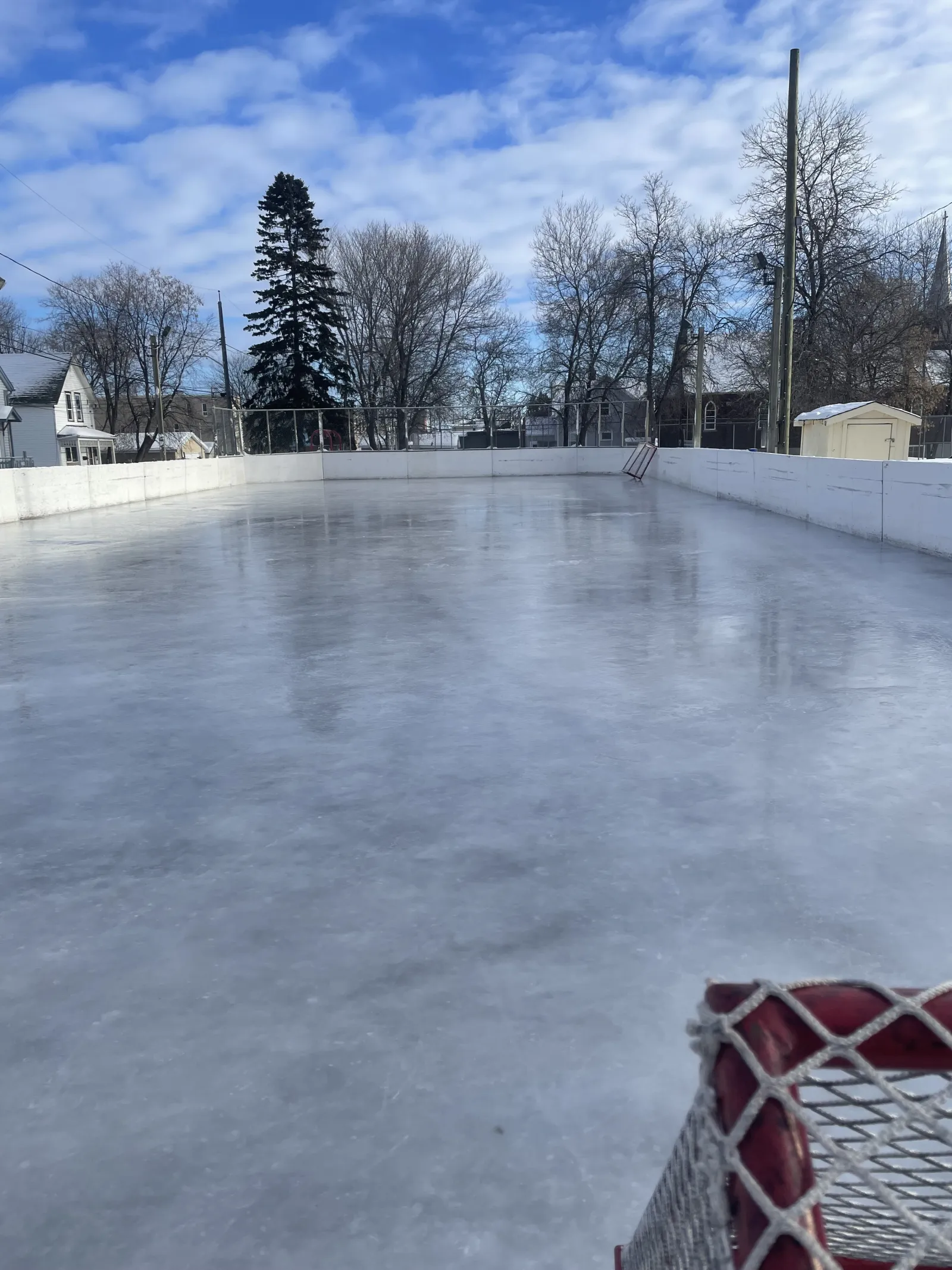 La pista con vallas de Wilson Street Park con una superficie de hielo despejada y una portería en la esquina — Wilson Street Park Outdoor Rink