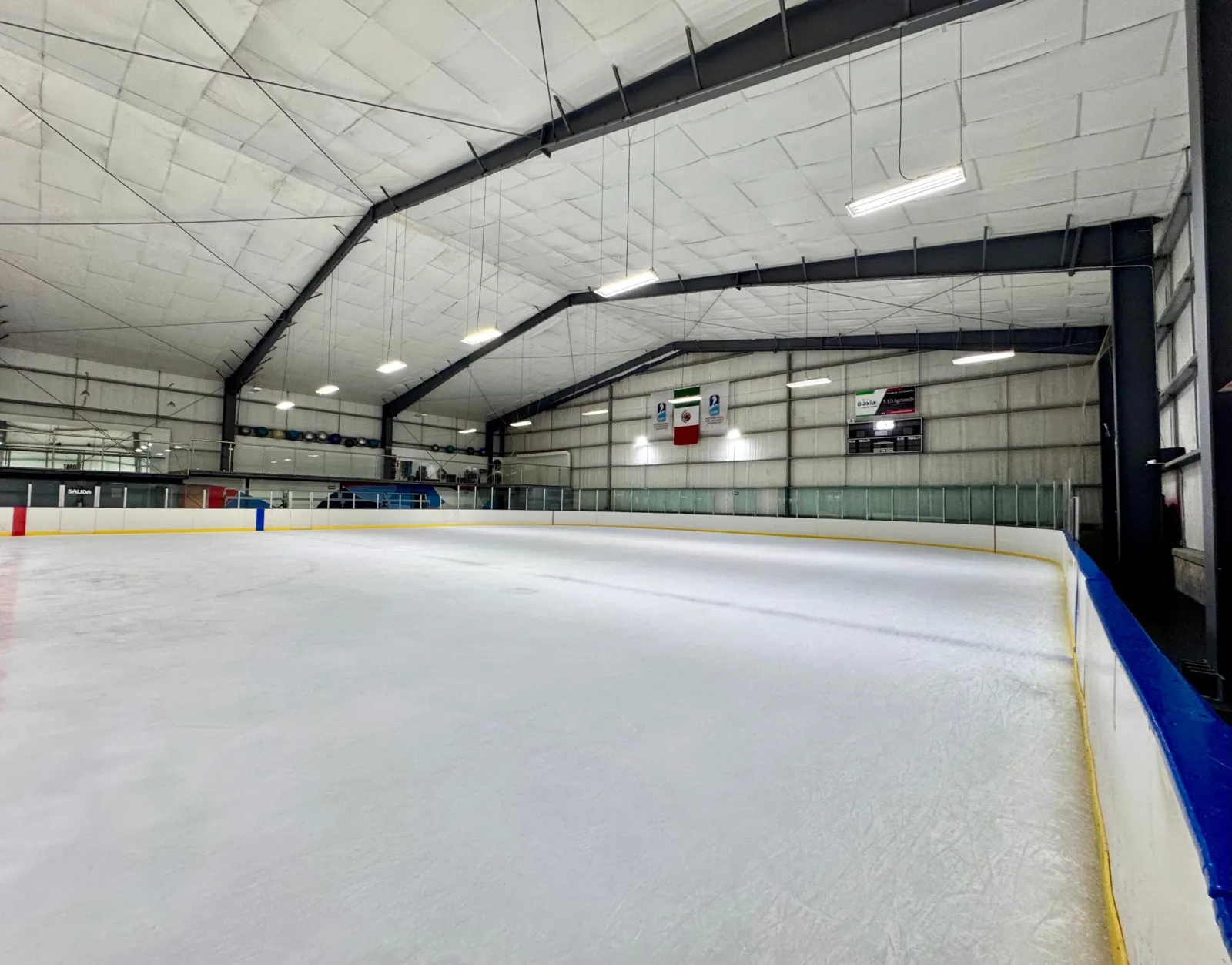 El hielo vacío del Winter Sports Center de Metepec dentro de su nave con estructura de acero, con bandas y luces a lo largo del lado largo. — Winter Sports Center Metepec