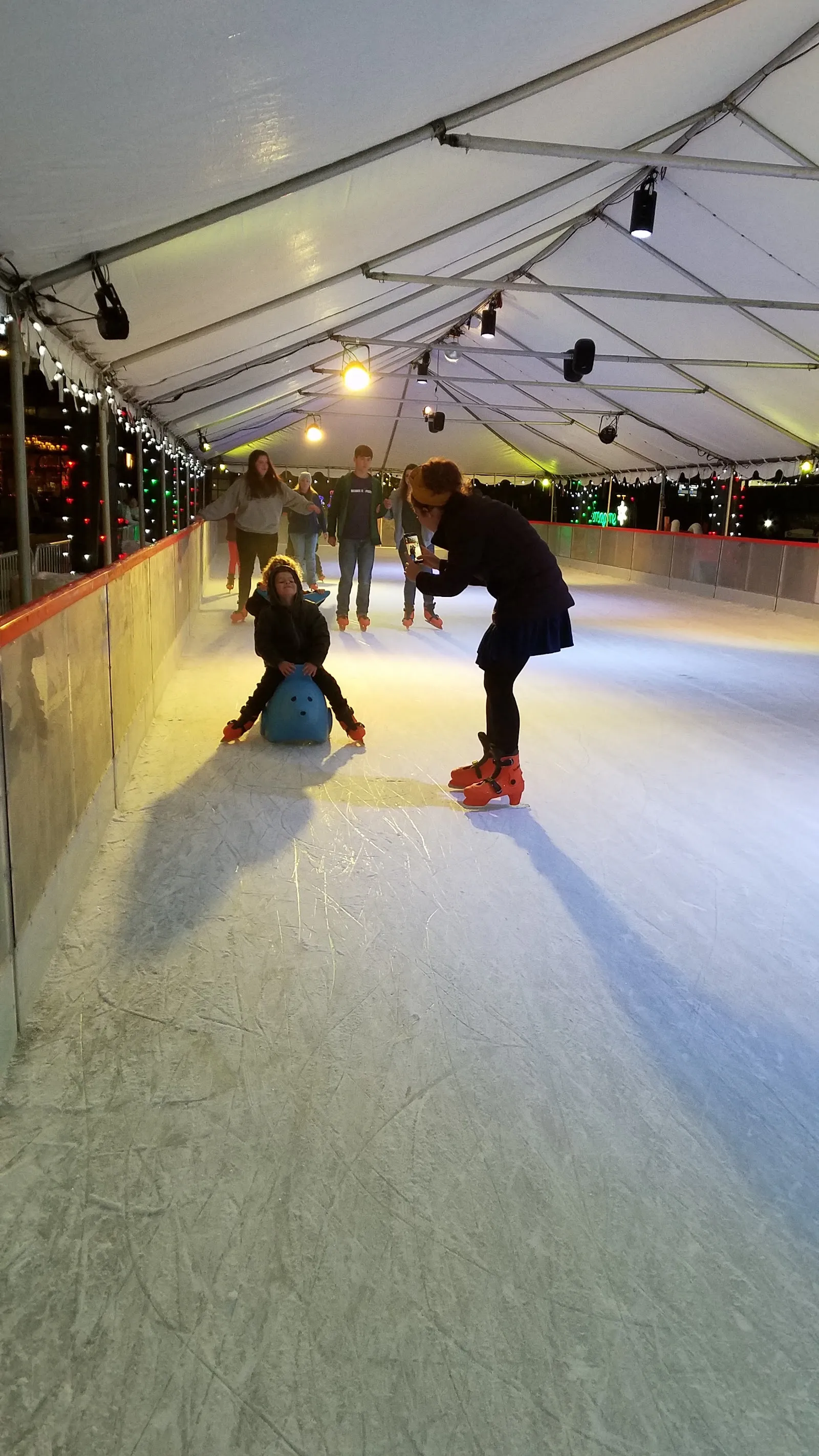 Skaters on the covered Winter Village ice rink at Jerry Willey Plaza — Winter Village at Orenco Station