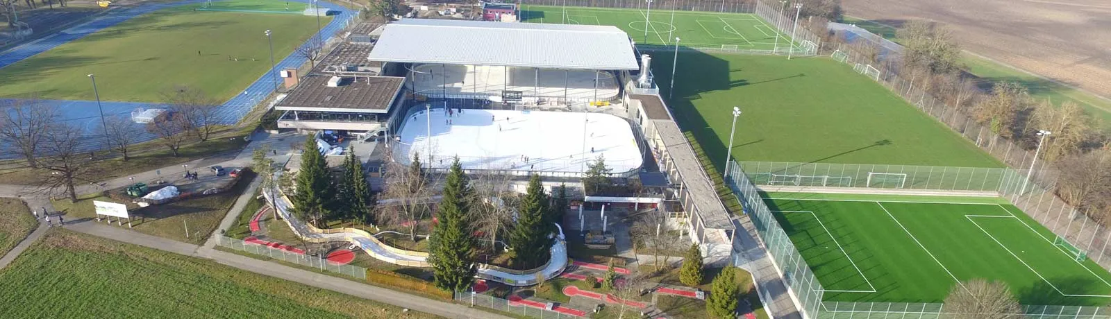 Aerial view of the Winter World in Wallisellen: the covered hall with its ice surface beside the football pitches — Winter World Wallisellen