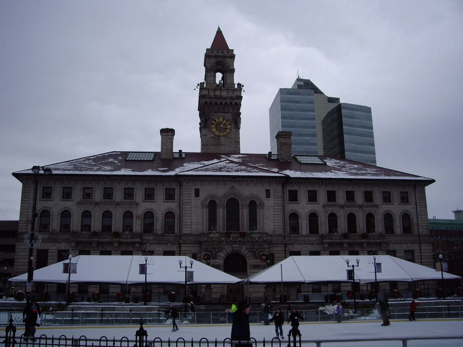 Worcester City Hall seen across the Common Oval skating rink, with a few skaters at the bottom of the frame — Worcester Common Oval
