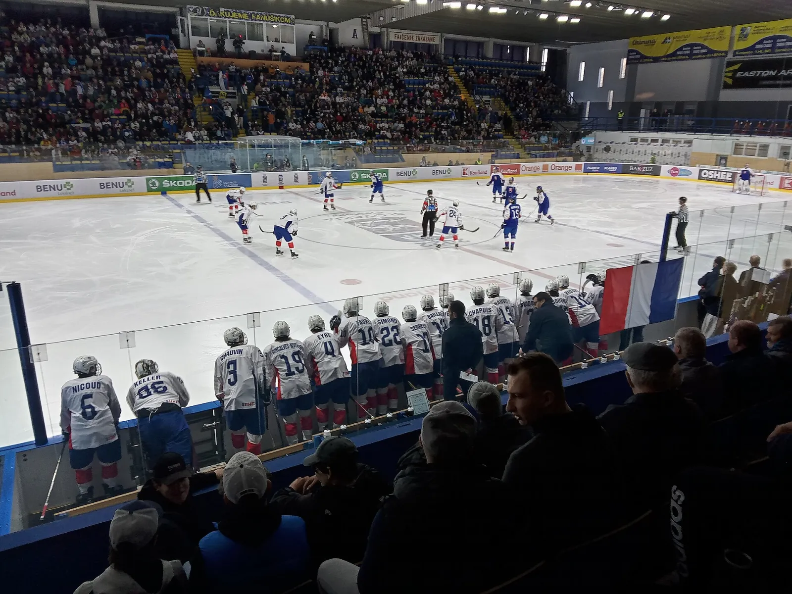 The ice sheet and stands of Zimný štadión Piešťany during an IIHF U18 World Championship game in 2022, seen from the gallery behind the boards. — Zimný štadión Piešťany