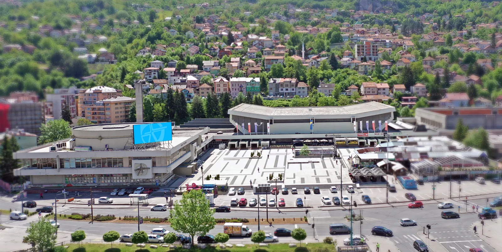 Pogled iz zraka na kompleks Skenderija s dvoranom Mirza Delibašić i prostorom ispred nje, ispod zelene padine — Zimska čarolija ice rink (Centar Skenderija)